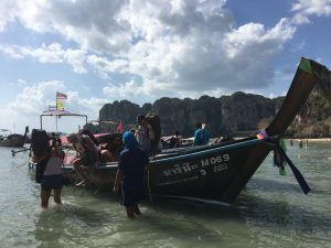 getting out of a long-tail boat right into the ocean